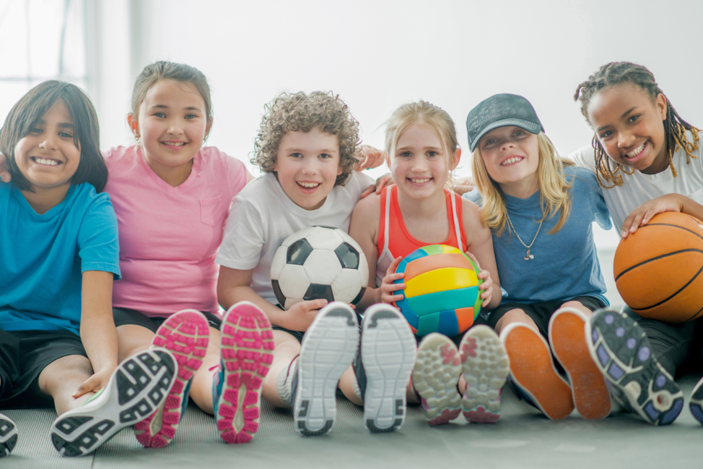 Children holding different sporting equipment